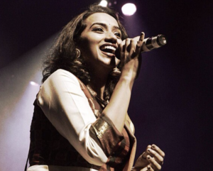 Kalpana Raghavendar performing on stage Singer Kalpana Raghavendar performing live on stage with a microphone in hand.